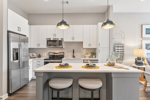 A modern kitchen with a large island and stainless steel appliances.
