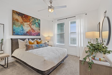 A bedroom with a large bed and a painting on the wall.