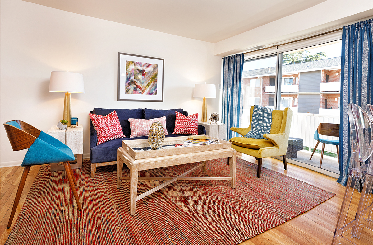 a living room with a blue couch and yellow chairs
