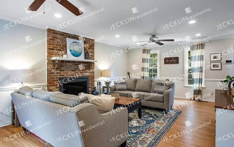 A living room with a grey sofa set and a fireplace.