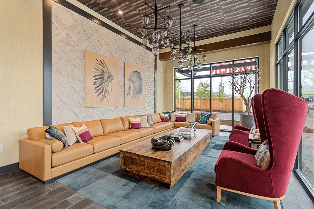 A living room with a tan couch and a red chair.