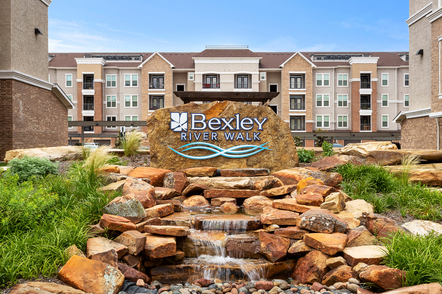 an outdoor fountain in front of a beekley river walk sign