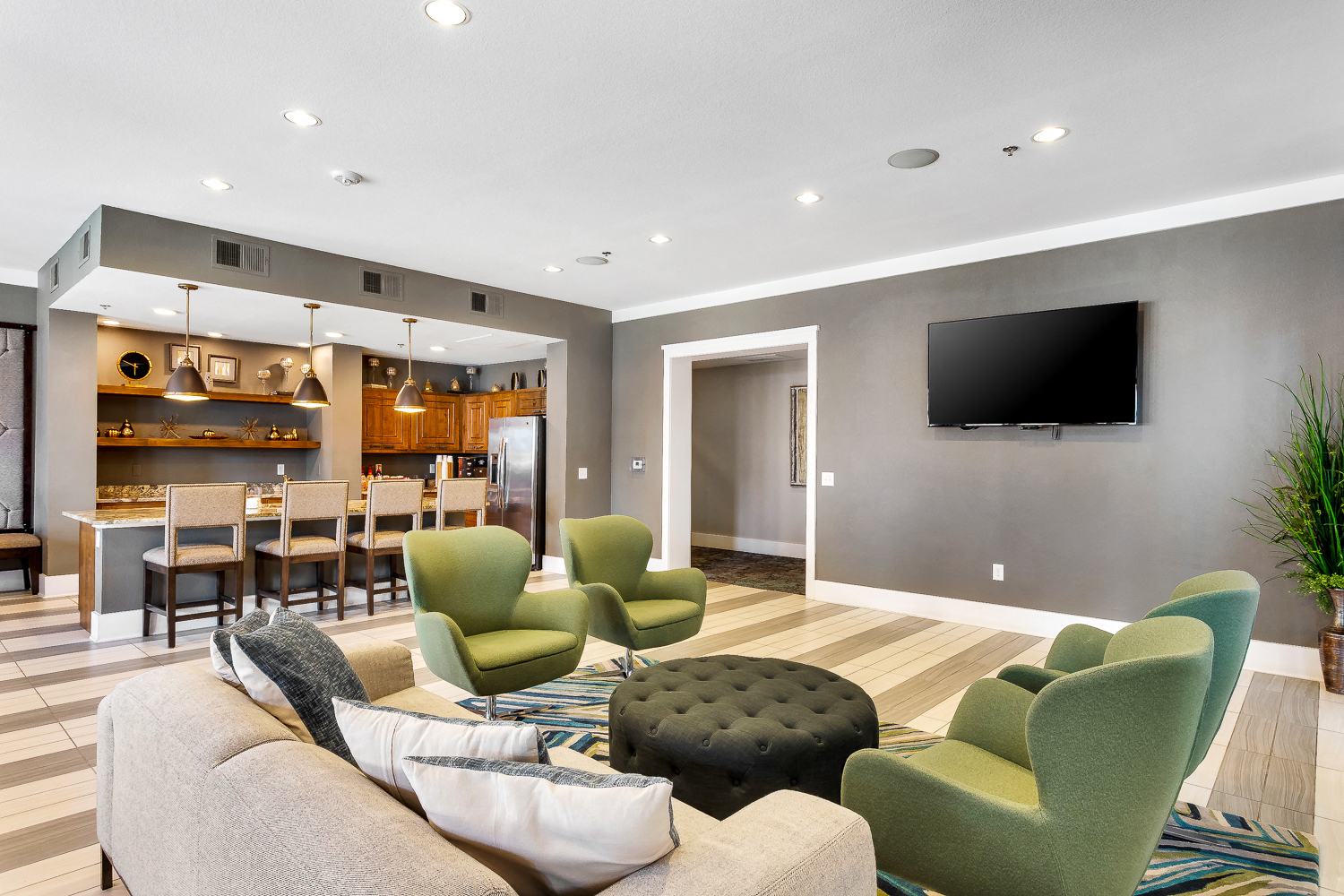 a living room with a couch and chairs and a tv