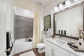 A bathroom with a white tub, toilet, and sink.