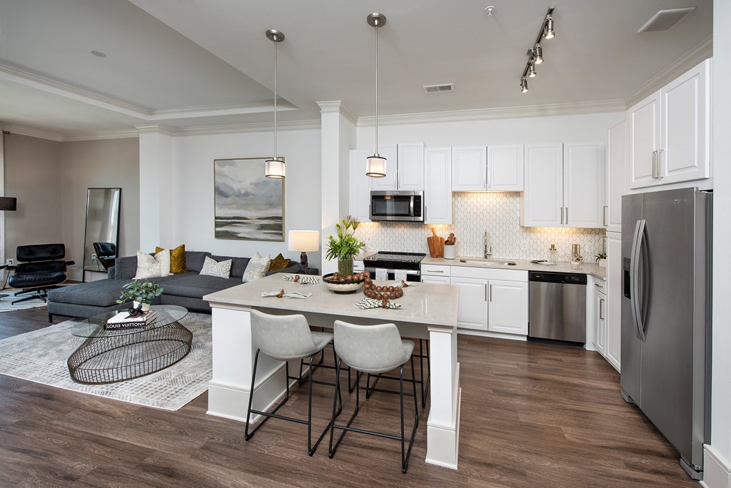 a kitchen and living room with white cabinets and a table
