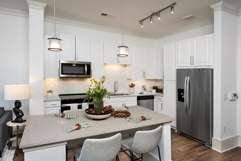 a kitchen with white cabinets and stainless steel appliances