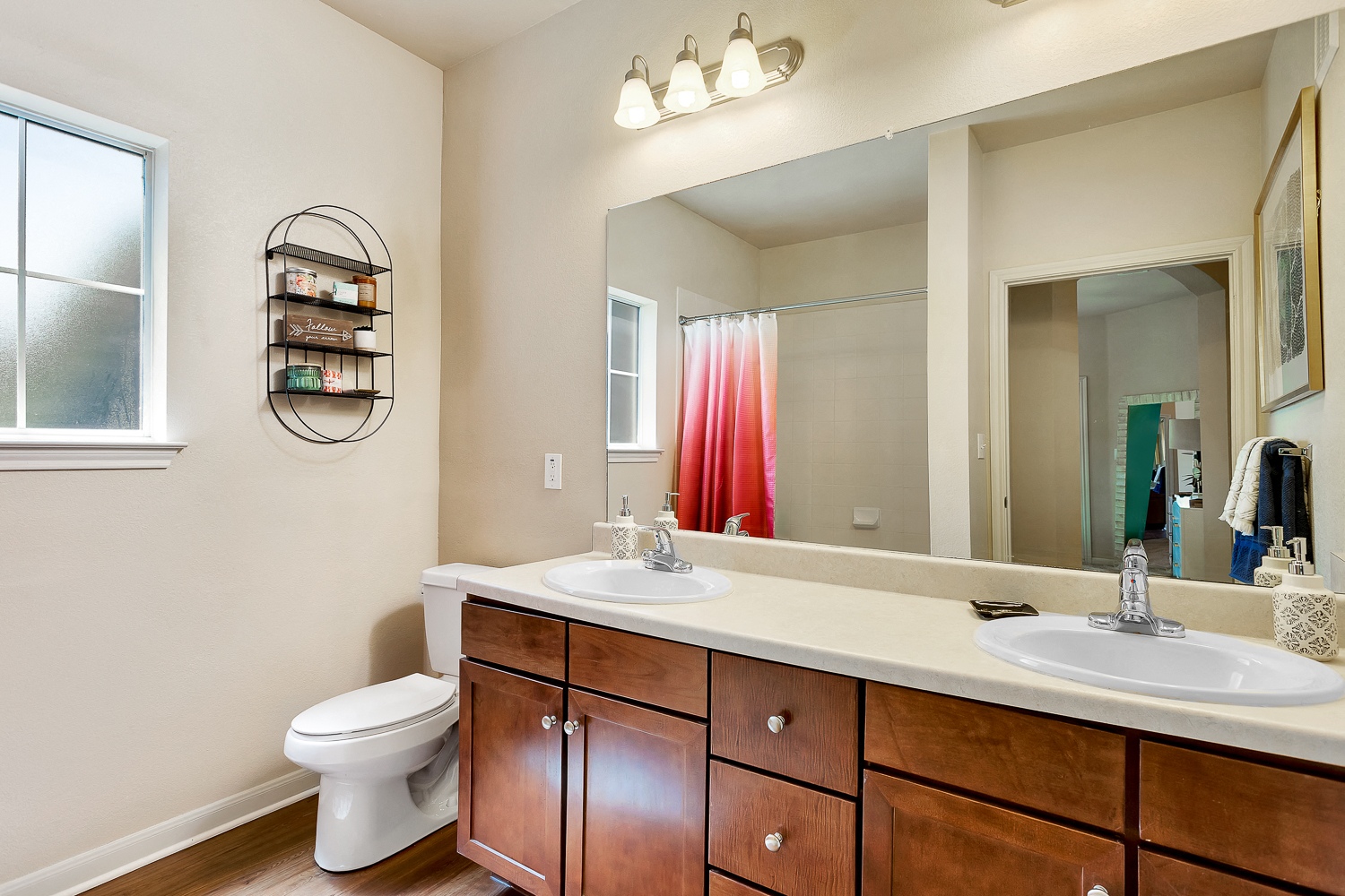 a bathroom with a large mirror and a toilet and sink
