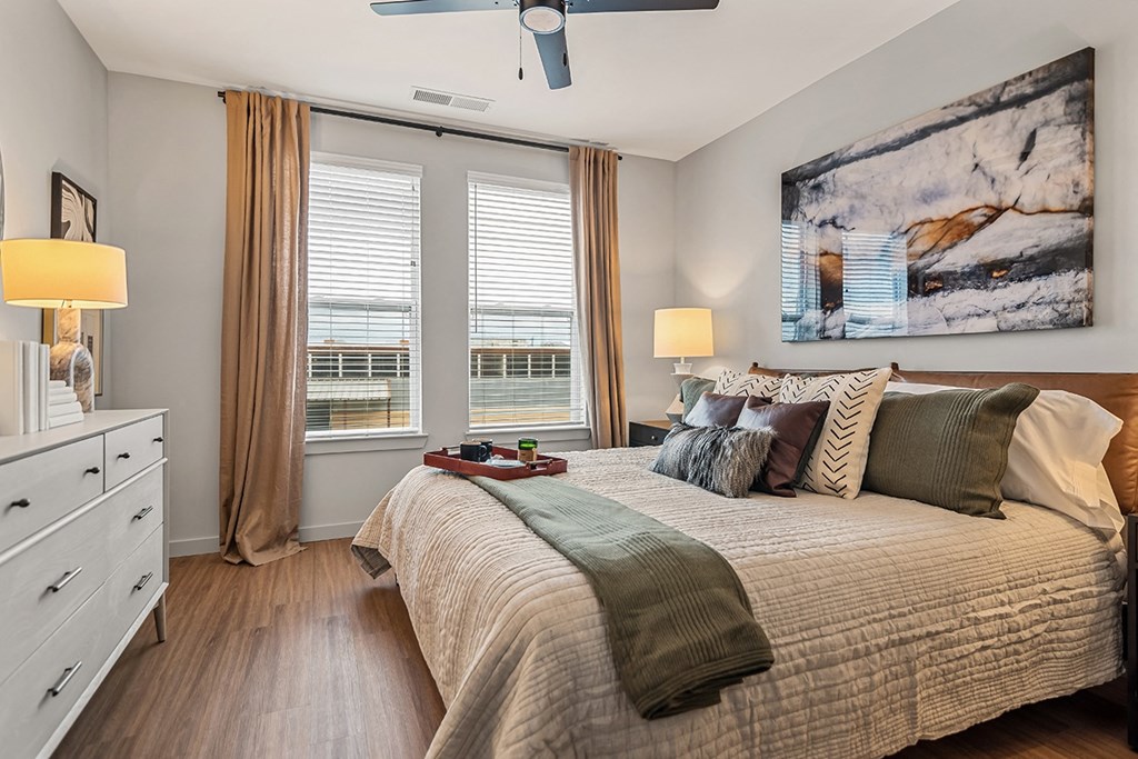 A bedroom with a large bed and a painting on the wall.