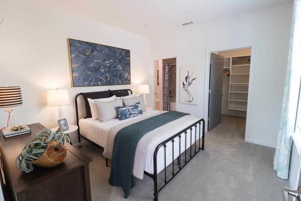 a bedroom with a bed and a painting on the wall