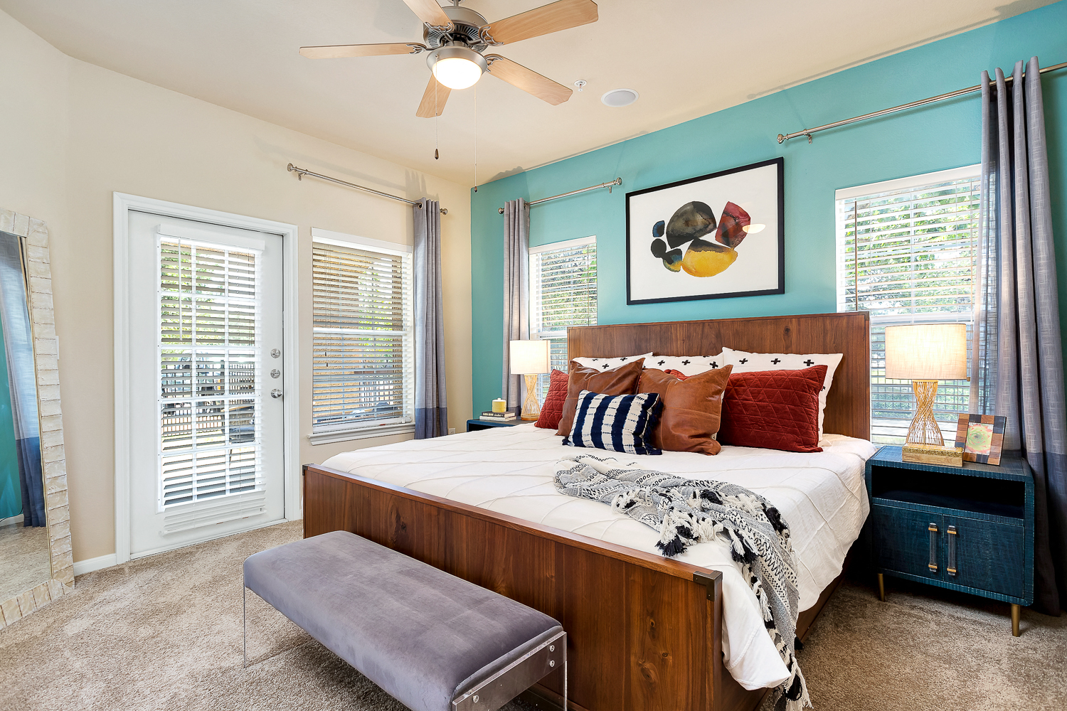a bedroom with a large bed and a ceiling fan