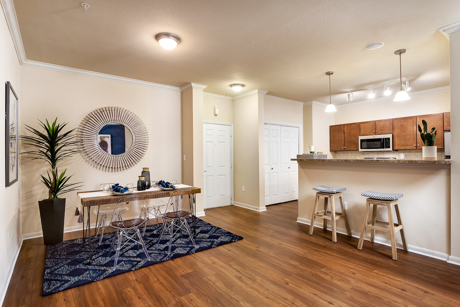 a living room with a kitchen and a bar with stools