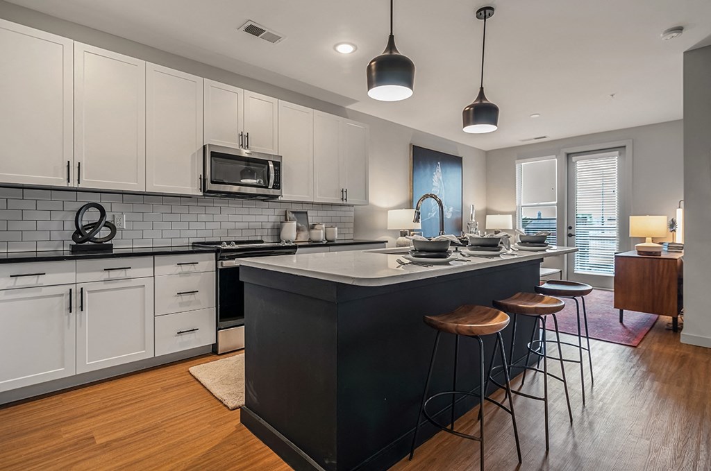 an open kitchen with a large island with three stools