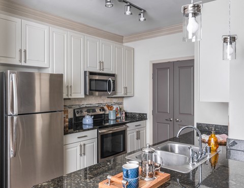 a kitchen with white cabinets and stainless steel appliances