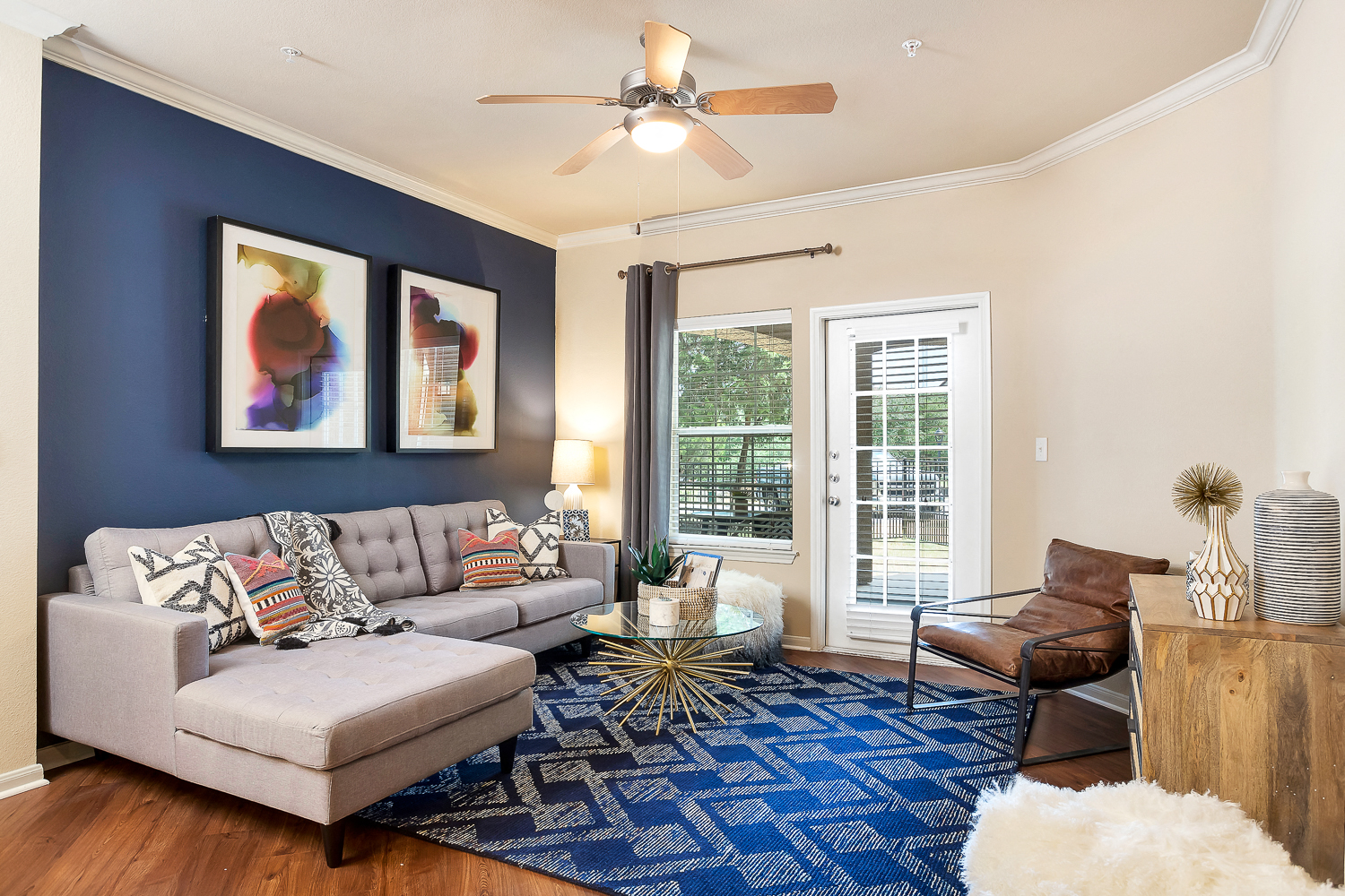 a living room with blue walls and a ceiling fan