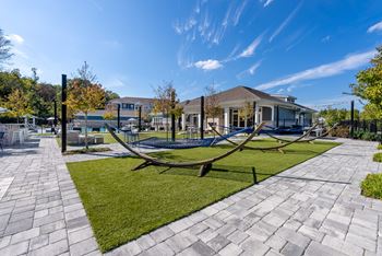 A playground with a swing set in the foreground and a building in the background.