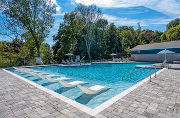 A large outdoor swimming pool surrounded by trees.