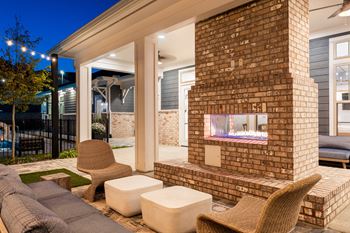 A patio with a fireplace and seating area.