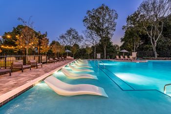 A long, lit, outdoor pool with steps.