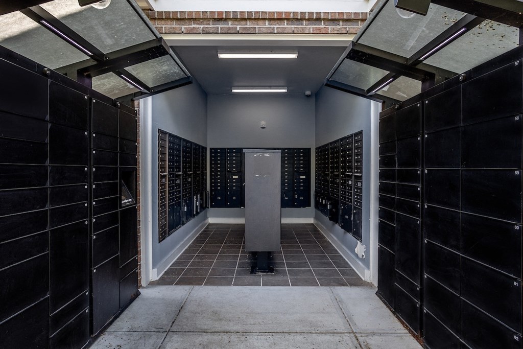 a look down a hallway with black tiles and a gray column in the middle