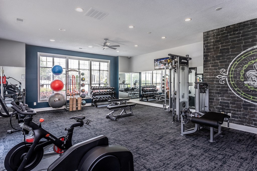 a gym with a brick wall and lots of exercise equipment