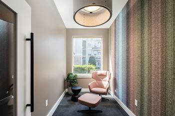 A hallway with a chair and a plant.