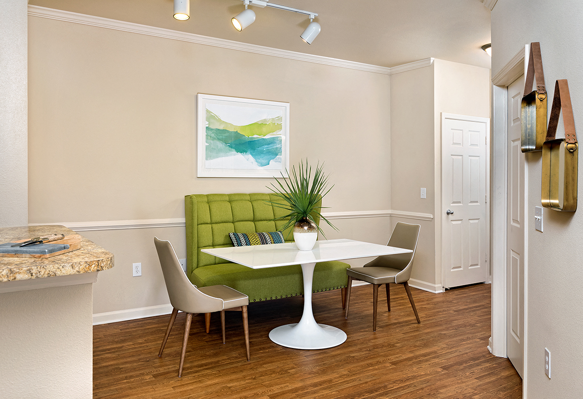 a dining room with a table and chairs and a green couch