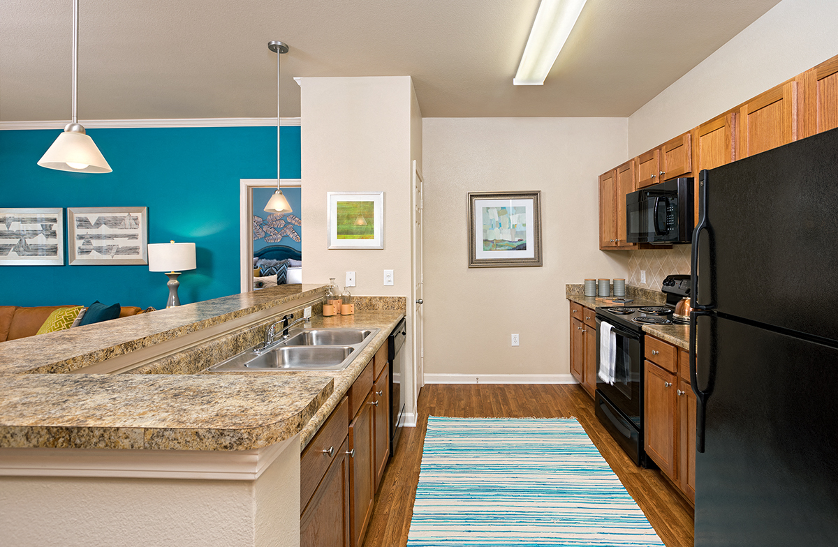 a kitchen with a granite counter top and a black refrigerator