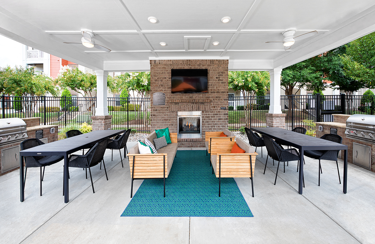 a patio with tables and chairs and a fireplace