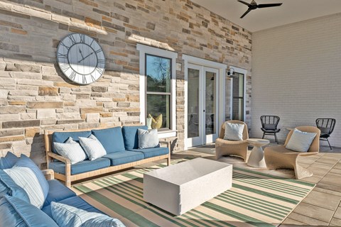 A living room with a blue couch and a stone wall.