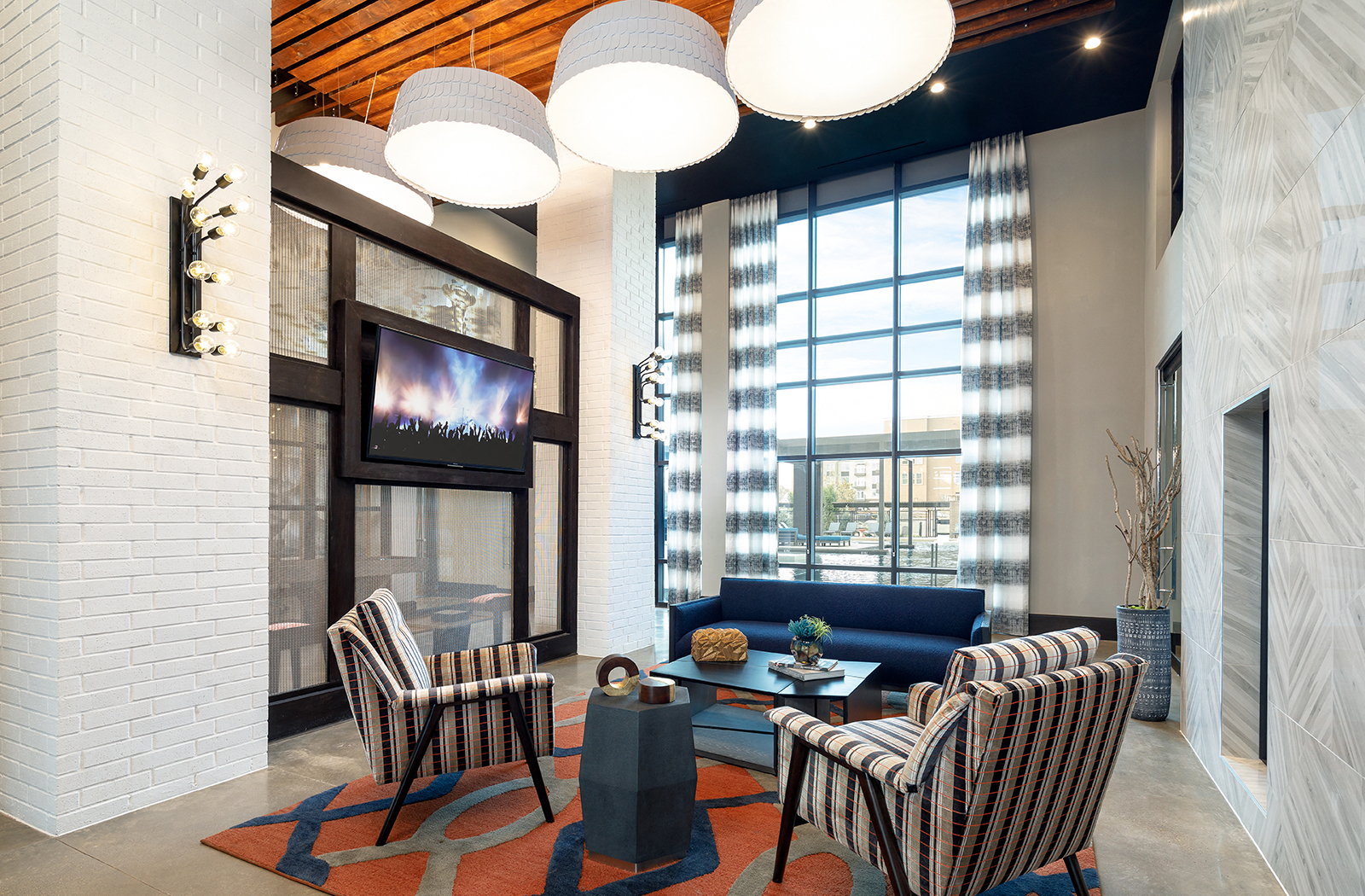 a living room with a blue couch and chairs and a television