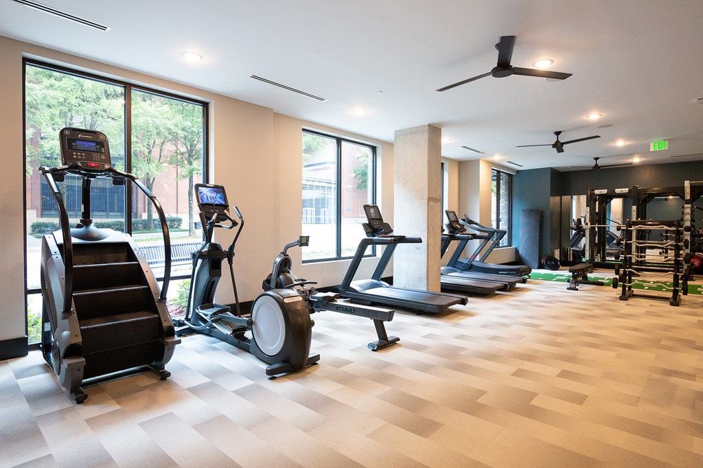 a gym with treadmills and other exercise equipment on a wooden floor