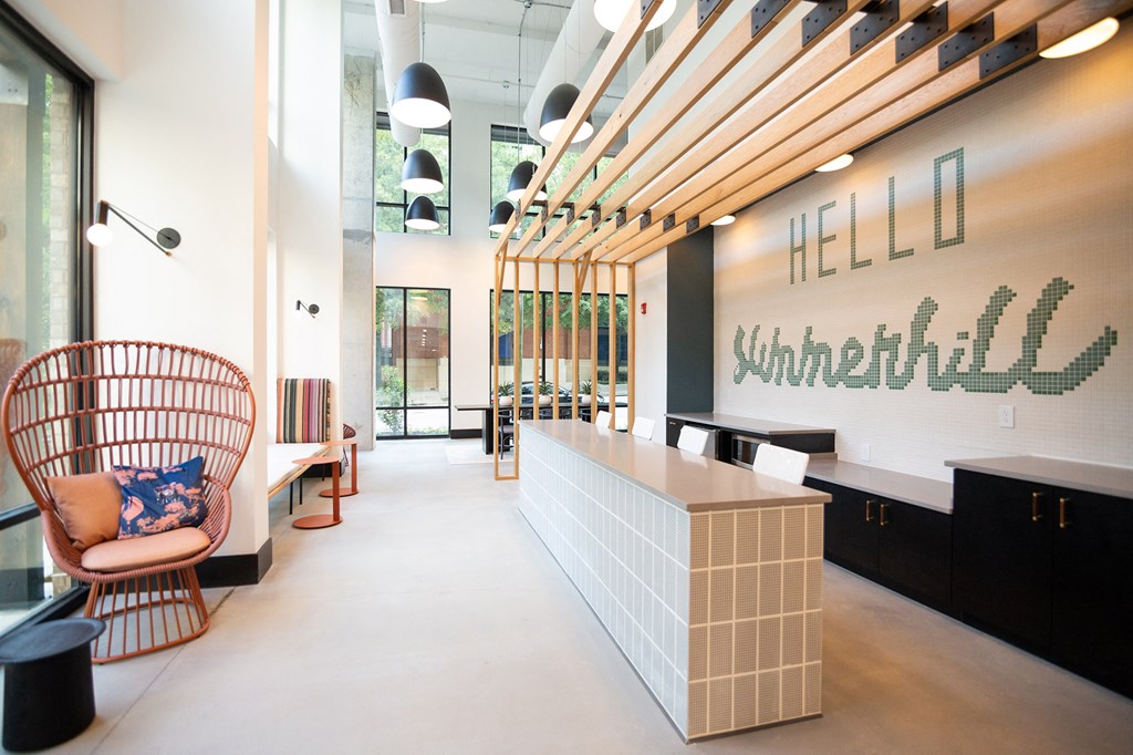 a reception area with a chair and a counter and a sign on the wall