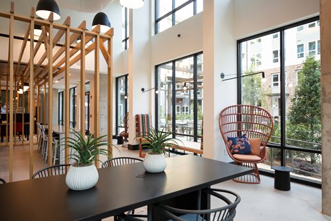 a dining room with a table and chairs and large windows