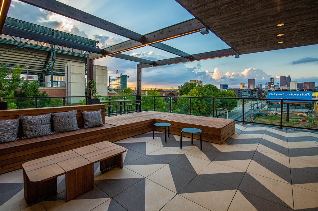 a rooftop terrace with benches and a view of the city