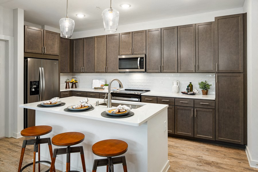 a kitchen with a large island with three stools