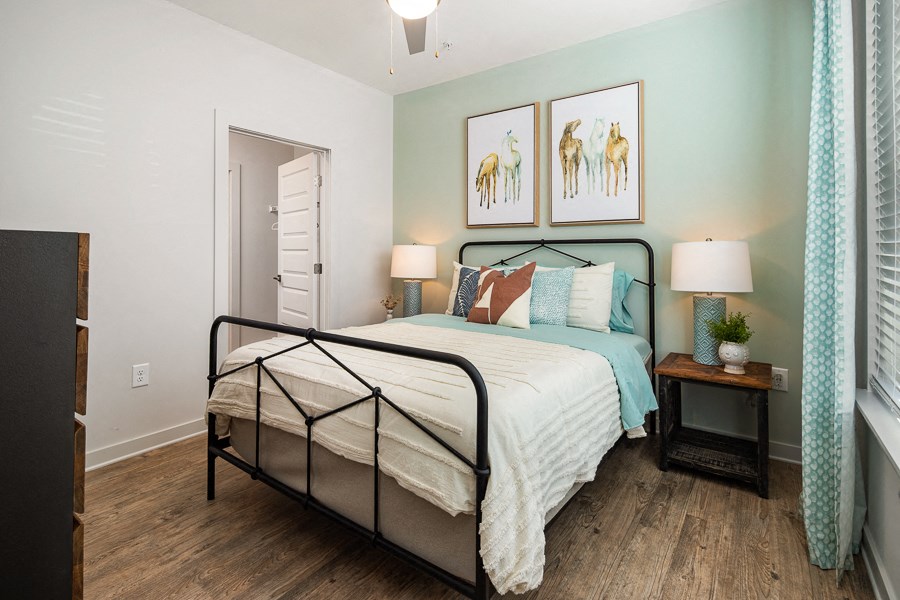 a bedroom with a bed and two paintings on the wall