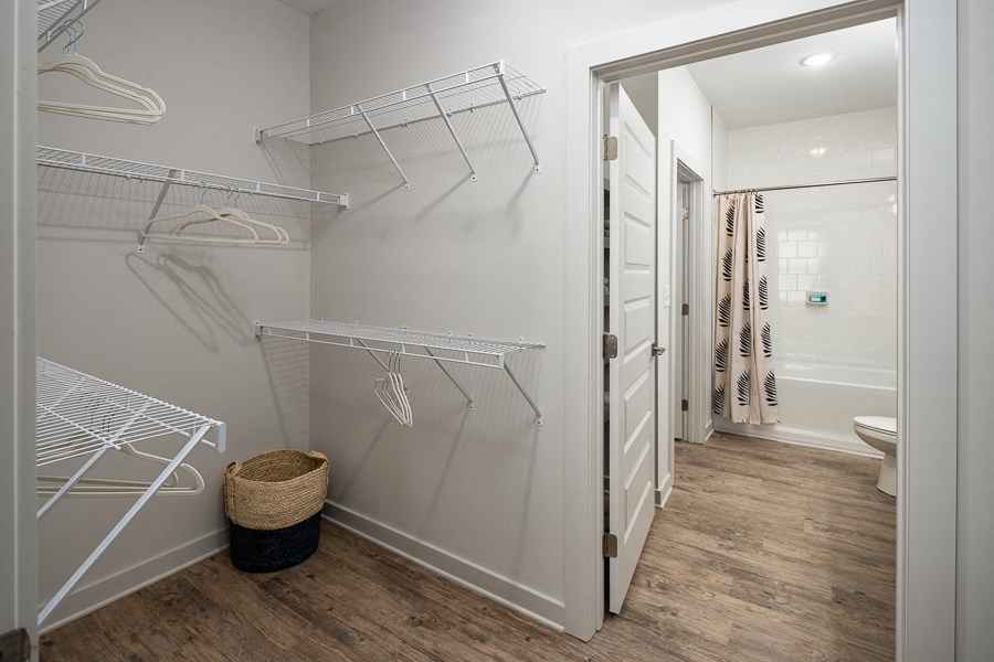 a walk in closet with hanging racks in a bathroom