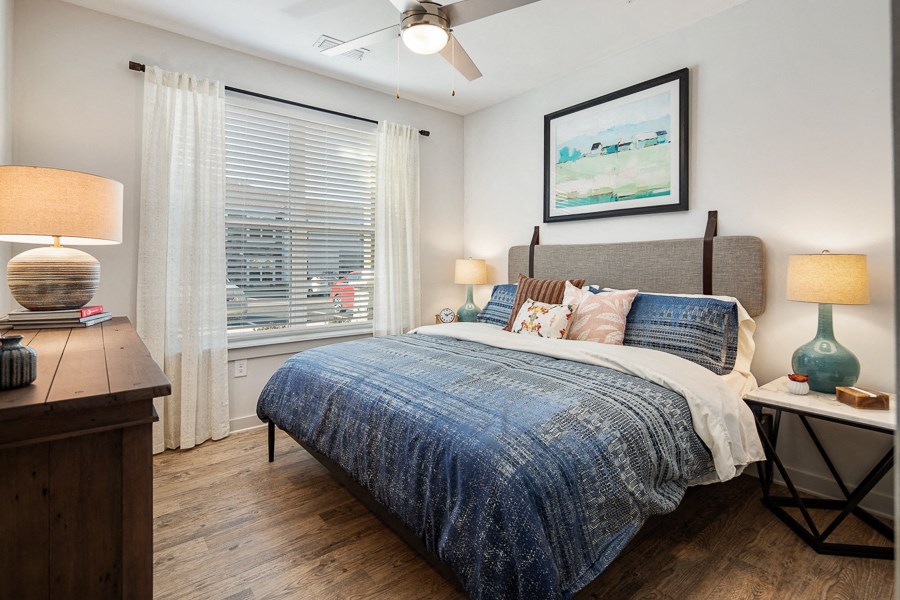 a bedroom with a large window and a bed