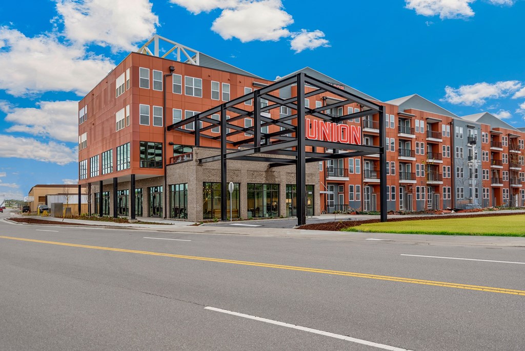 A large brick building with a black metal frame in front of it.