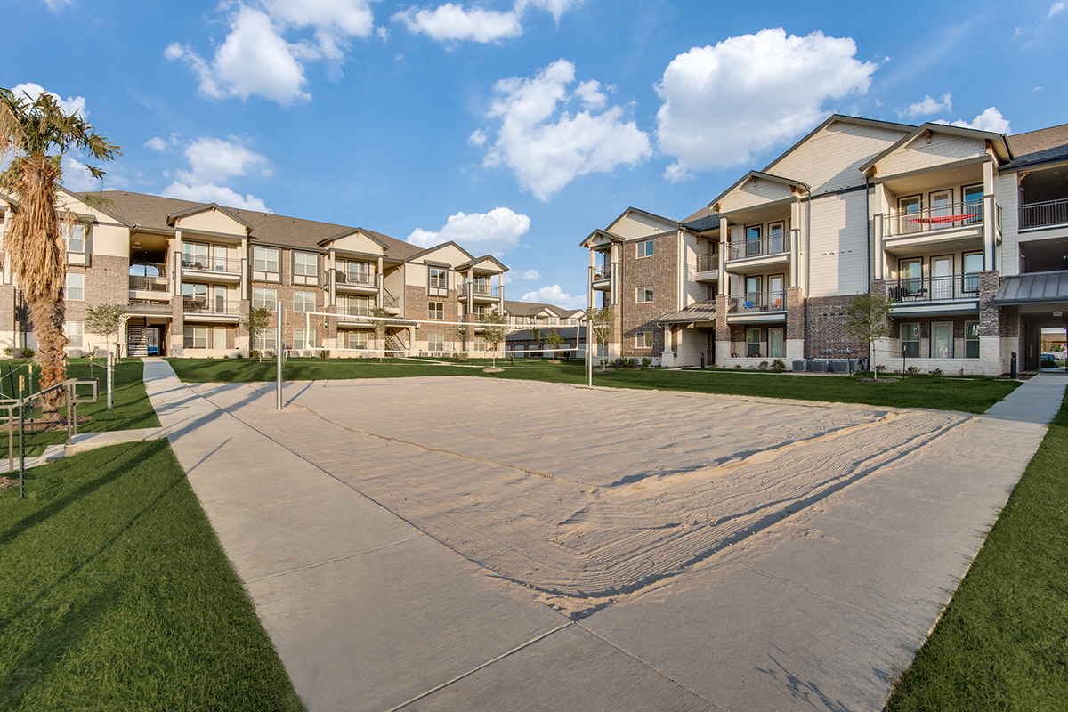 an empty basketball court in front of an apartment building