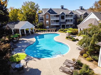 an aerial view of a swimming pool with an apartment building in the background