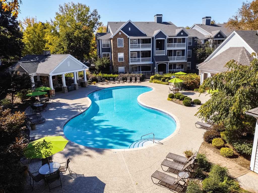 an aerial view of a swimming pool with an apartment building in the background