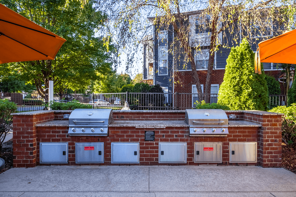 a brick barbecue with four ovens on it in front of a house