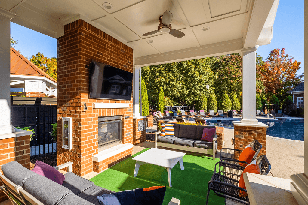 a backyard with a fireplace and a pool with lounge chairs and a table