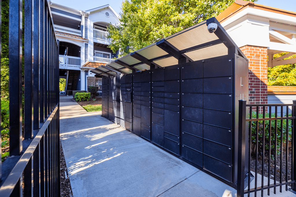 the gate to the driveway of an apartment building with a black fence