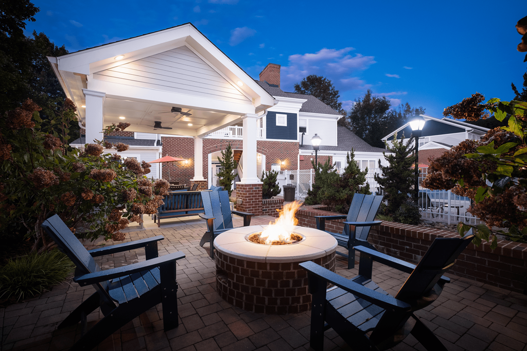 an outdoor patio with a fire pit and chairs