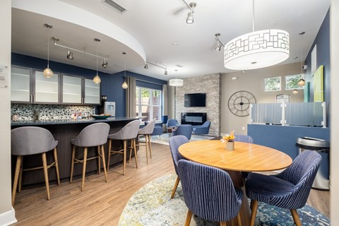 A modern kitchen with a bar area and a dining table set up.