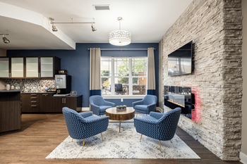 a living room with blue chairs and a fireplace