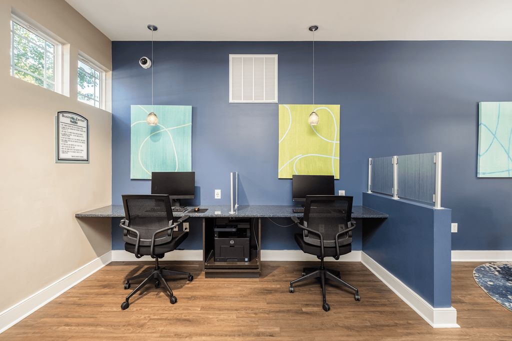 a conference room with desks and chairs and paintings on the wall