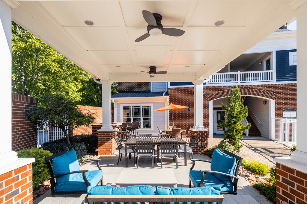 a patio with a table and chairs and a ceiling fan